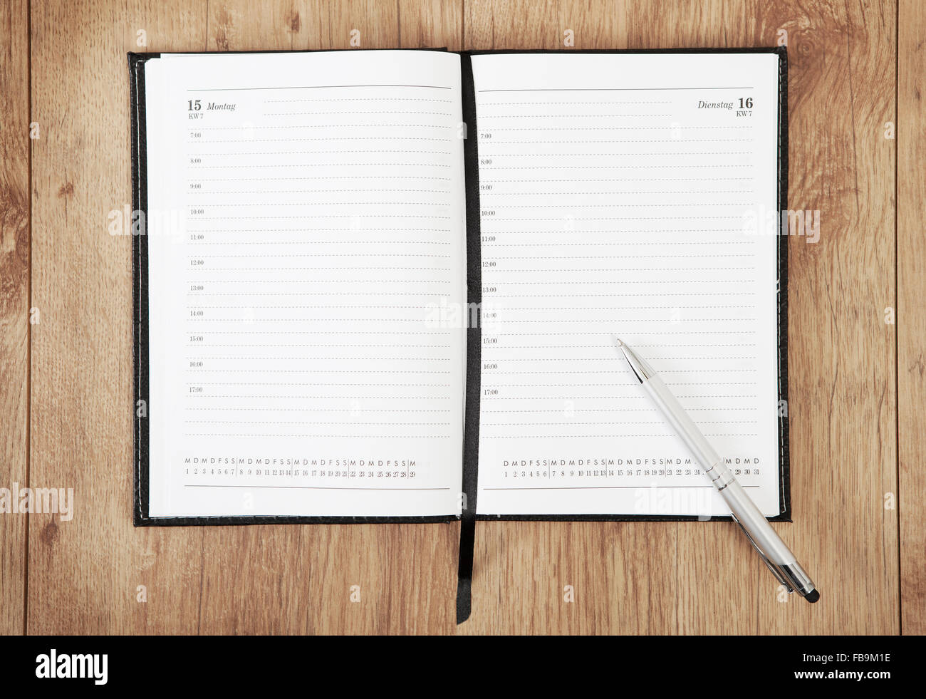 an unrecorded calendar with a pen lying on a wooden underground Stock Photo