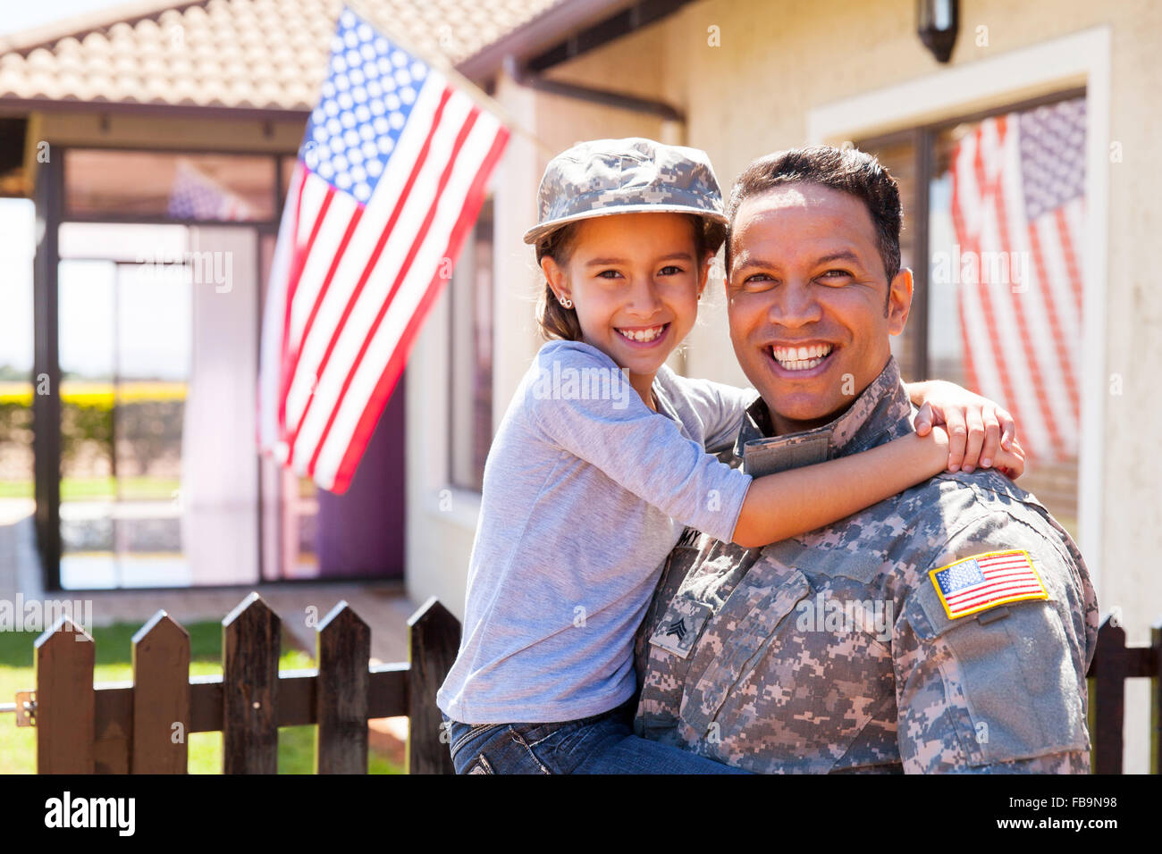 portrait of us army soldier and little daughter outside their home Stock Photo