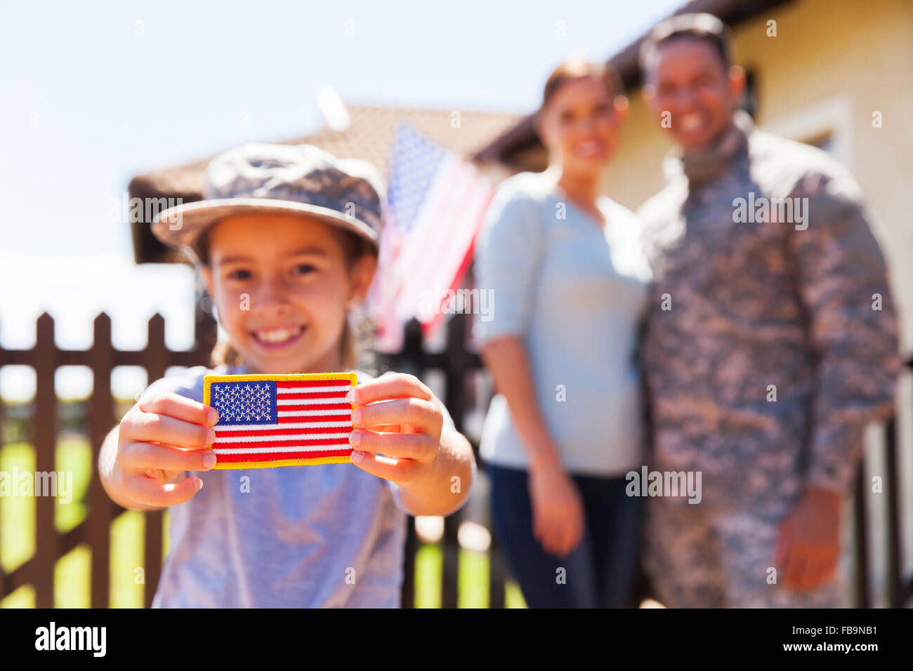 little girl holding American flag badge in front of parents Stock Photo