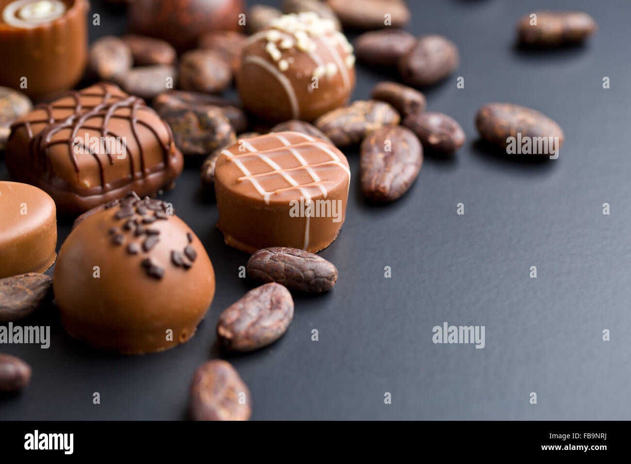 the chocolate pralines and cocoa beans Stock Photo