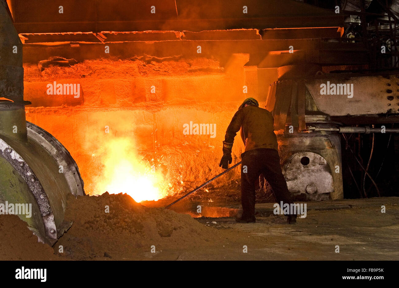 Man working at blast furnace iron tap hole. Stock Photo