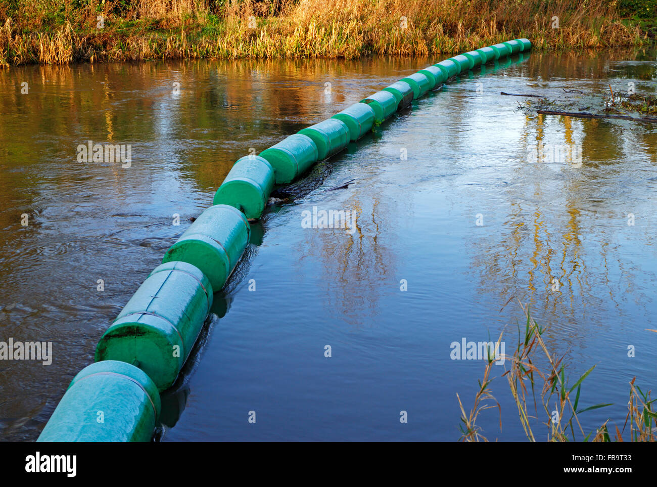 A boom on the River Bure upstream of the watermill at Horstead, Norfolk, England, United Kingdom. Stock Photo