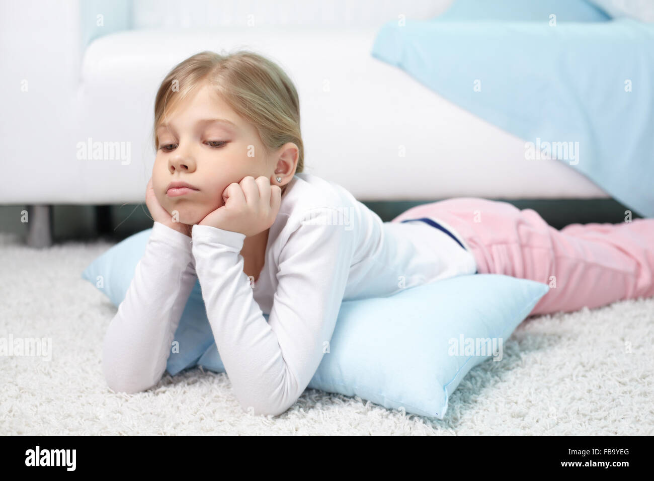 Sad little girl lying on the floor at home Stock Photo Alamy