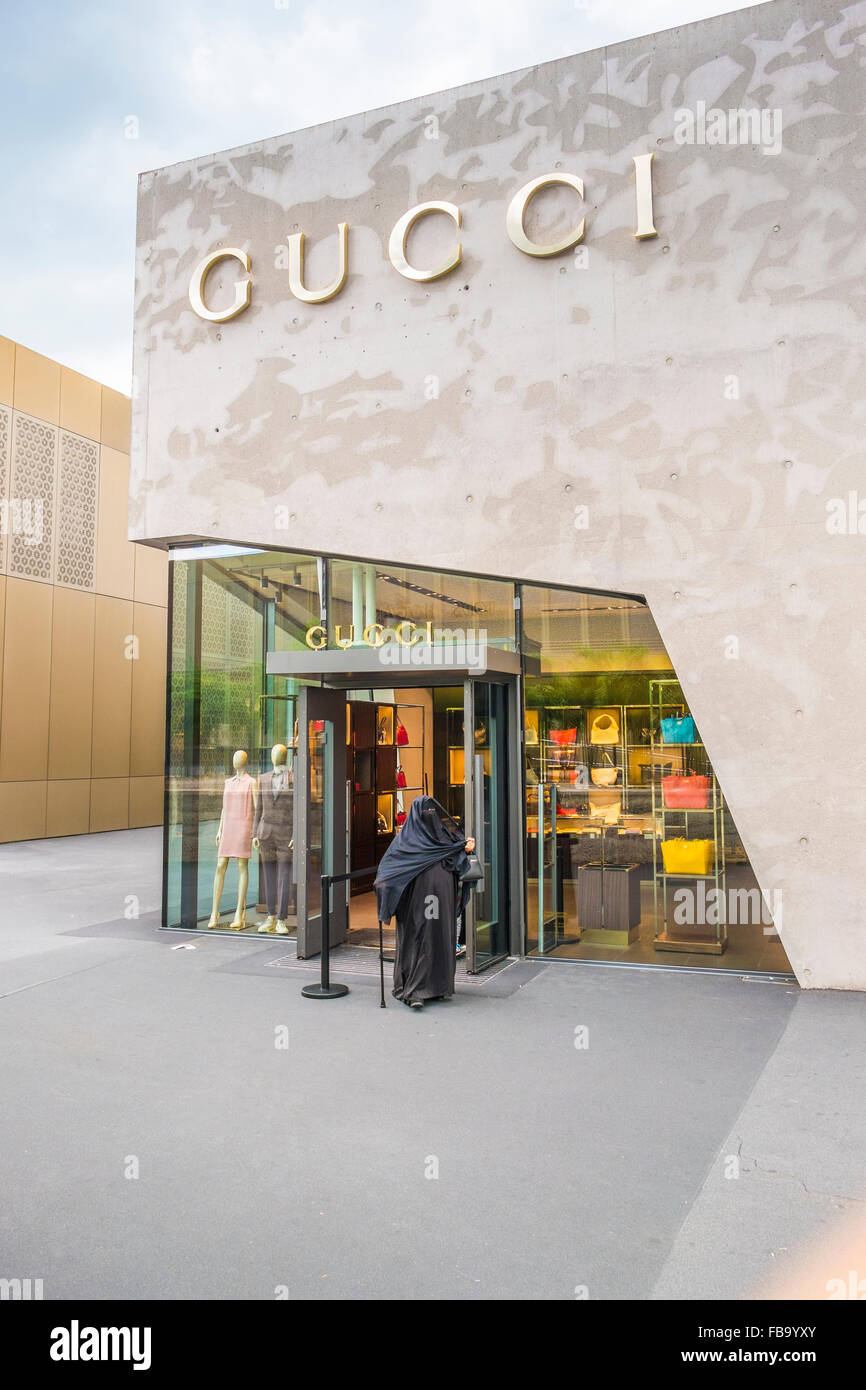 somewhat older woman wearing a burqa and holding a walking cane in front of the gucci-store, outlet city, metzingen Stock Photo