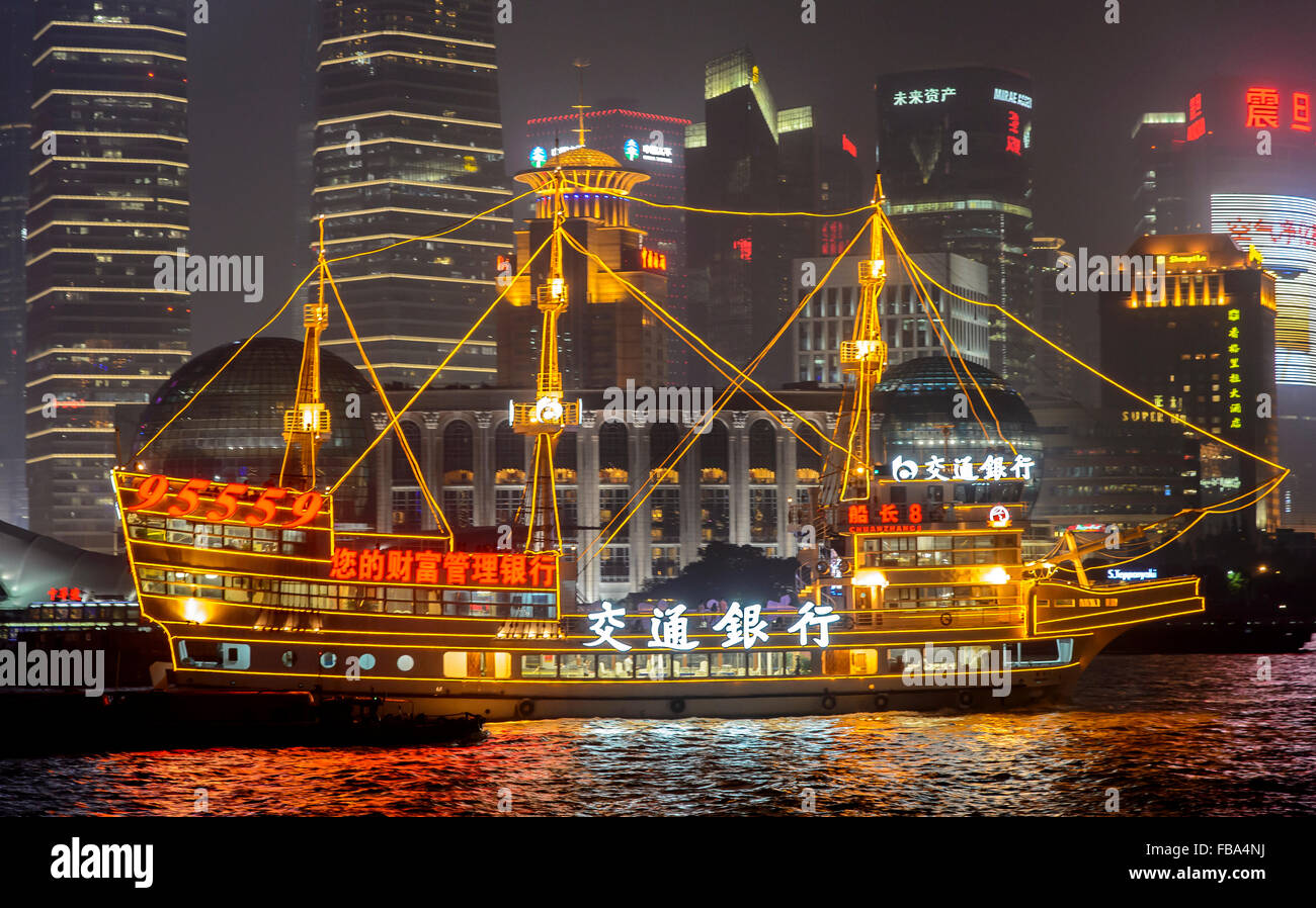 China, Shanghai, Sailboat against modern buildings at night Stock Photo