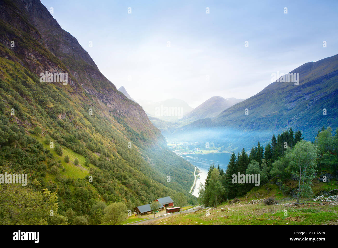 Norway, More og Romsdal, Sunnmore, Geiranger, Mountain valley with misty lake Stock Photo