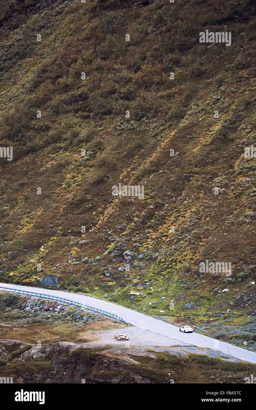 Norway, More og Romsdal, Sunnmore, Geirangerfjord, Car driving along Trollstigen road at foot of mountain Stock Photo