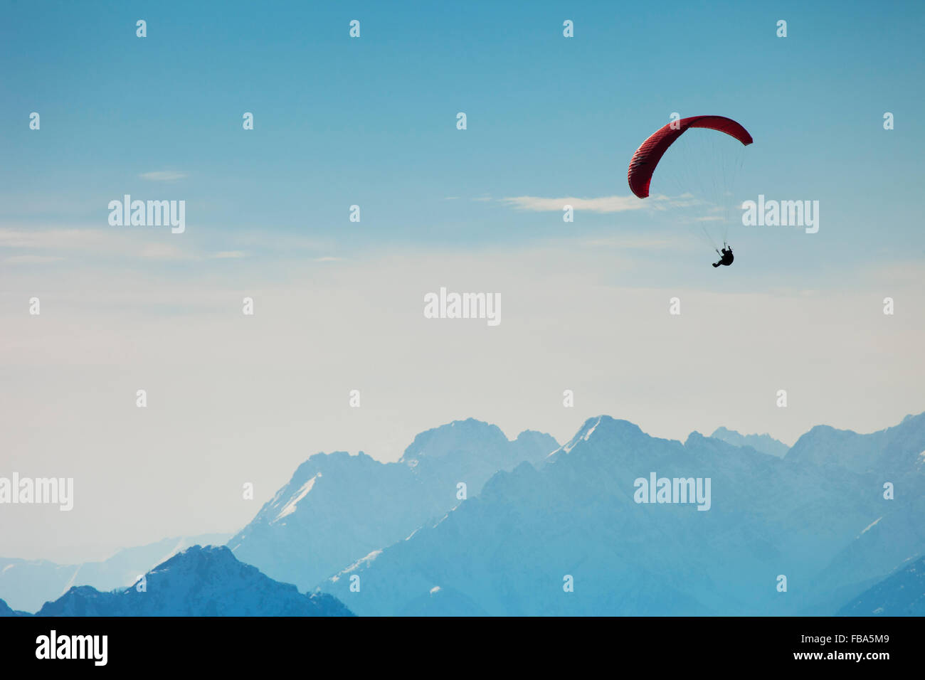Austria, Tyrol, Man paragliding in mountains Stock Photo