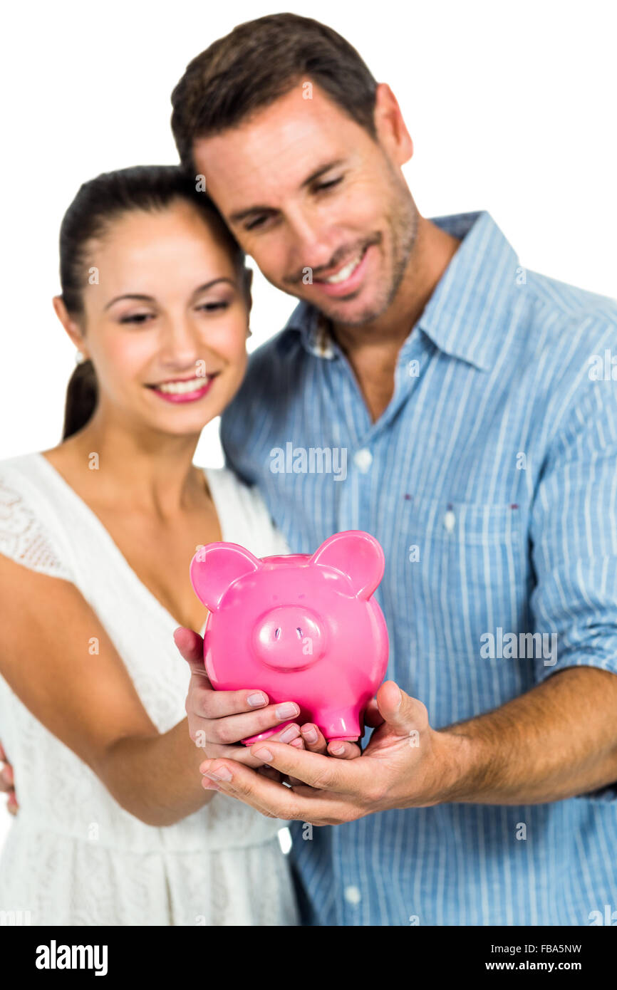 Happy couple holding piggybank Stock Photo - Alamy