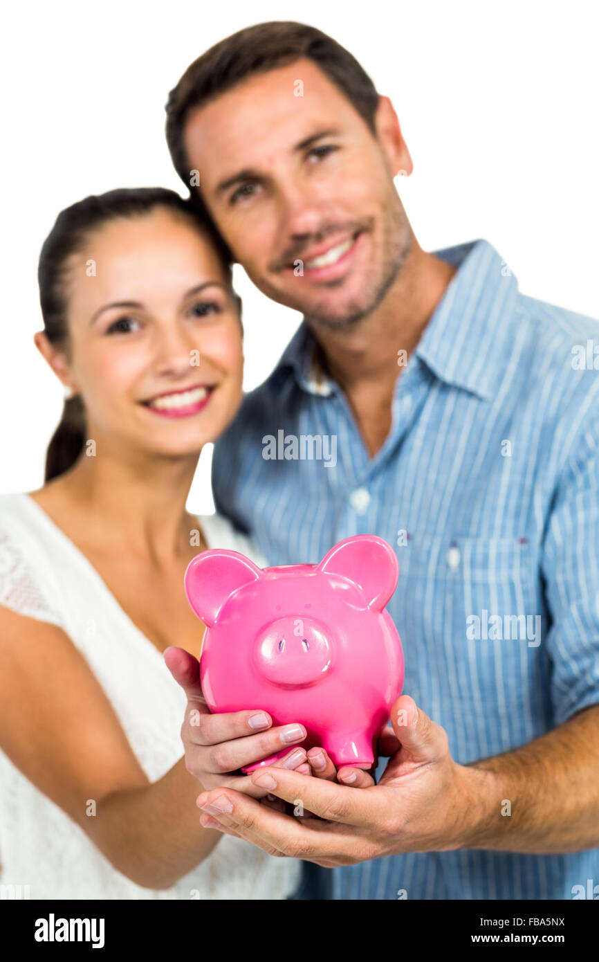 Portrait of couple holding piggybank Stock Photo - Alamy
