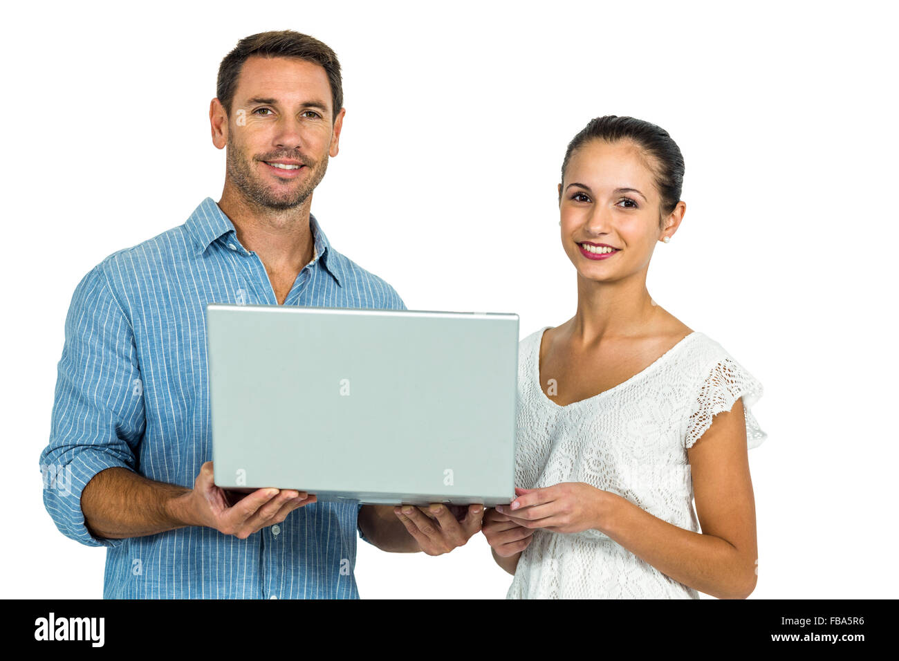 Young couple holding laptop and looking at camera Stock Photo - Alamy