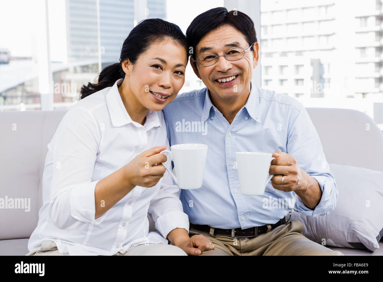 Potrait of couple enjoying coffee on the couch Stock Photo