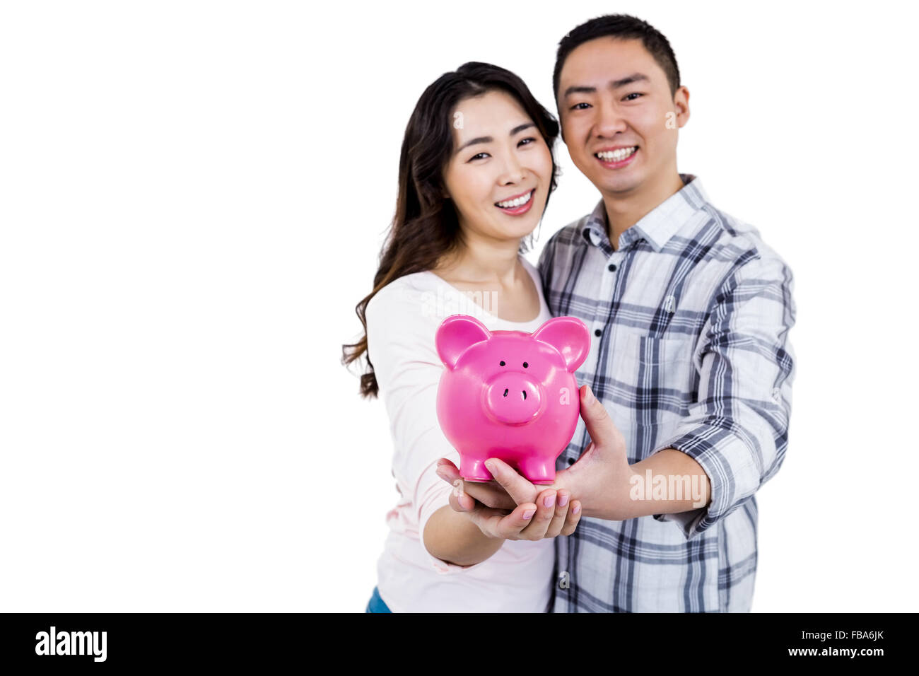Portrait of cheerful couple holding piggy bank Stock Photo - Alamy