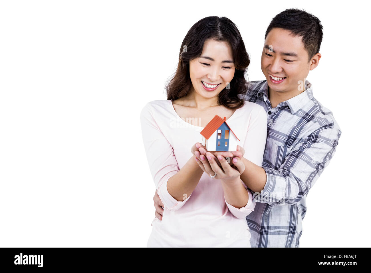 Happy couple holding a model house Stock Photo - Alamy