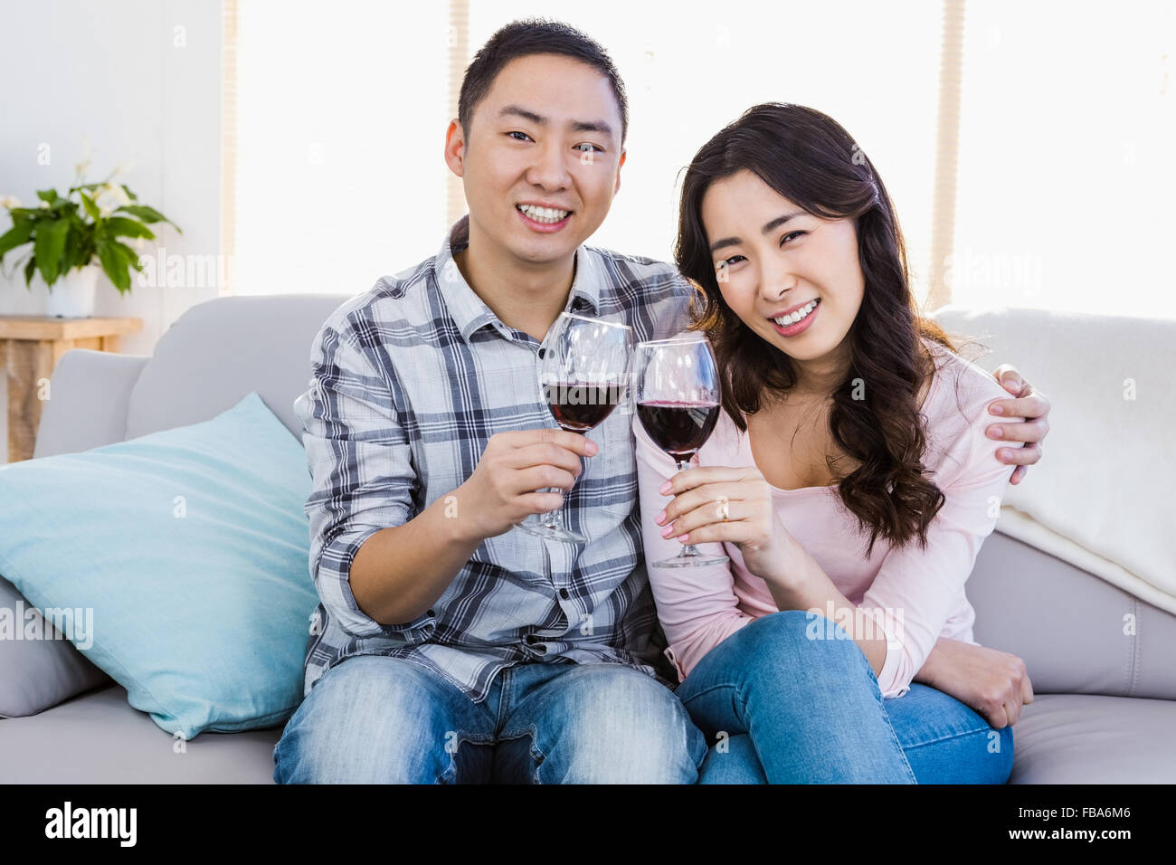 Happy young couple holding wineglasses Stock Photo - Alamy