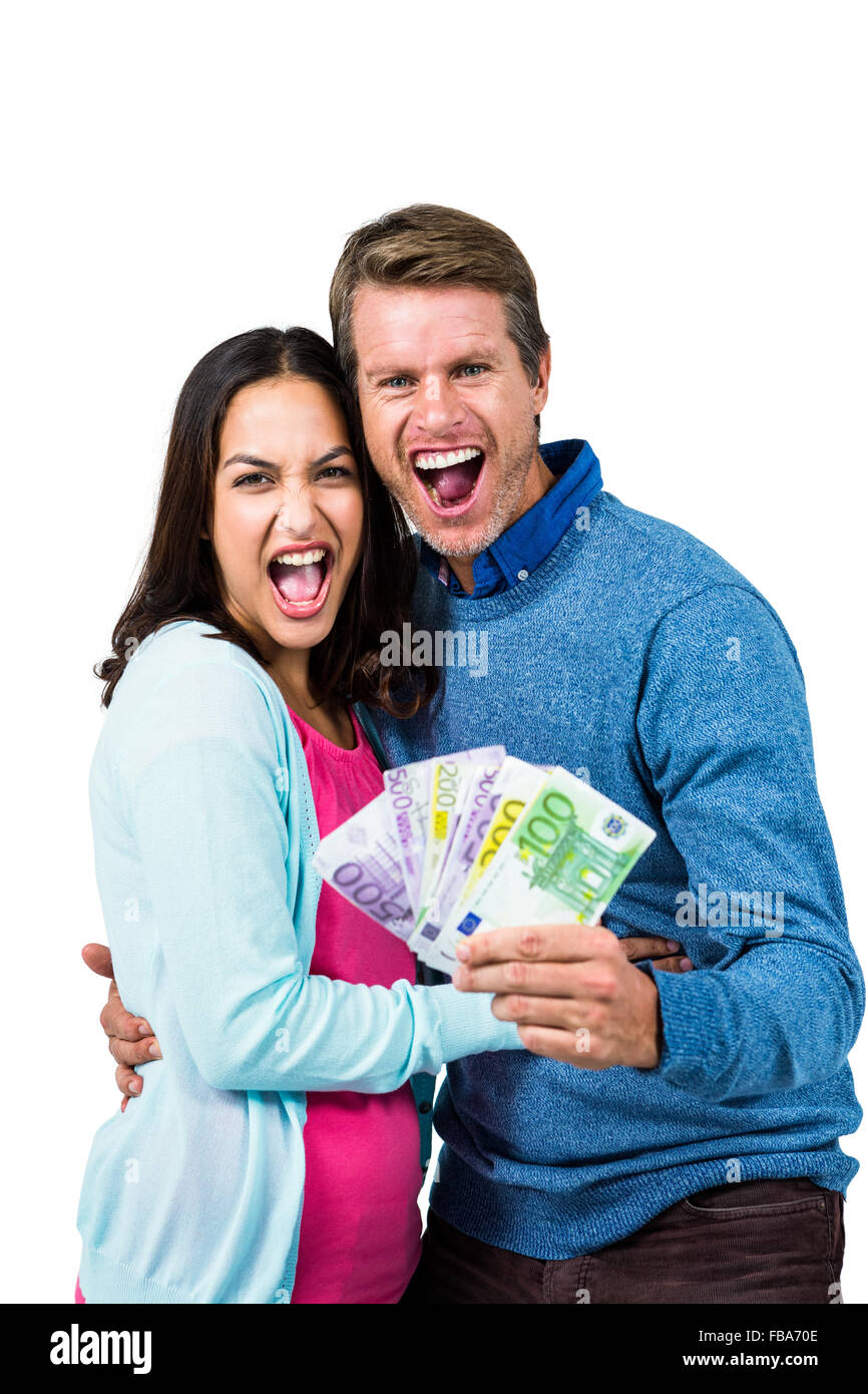 Excited couple holding money Stock Photo - Alamy
