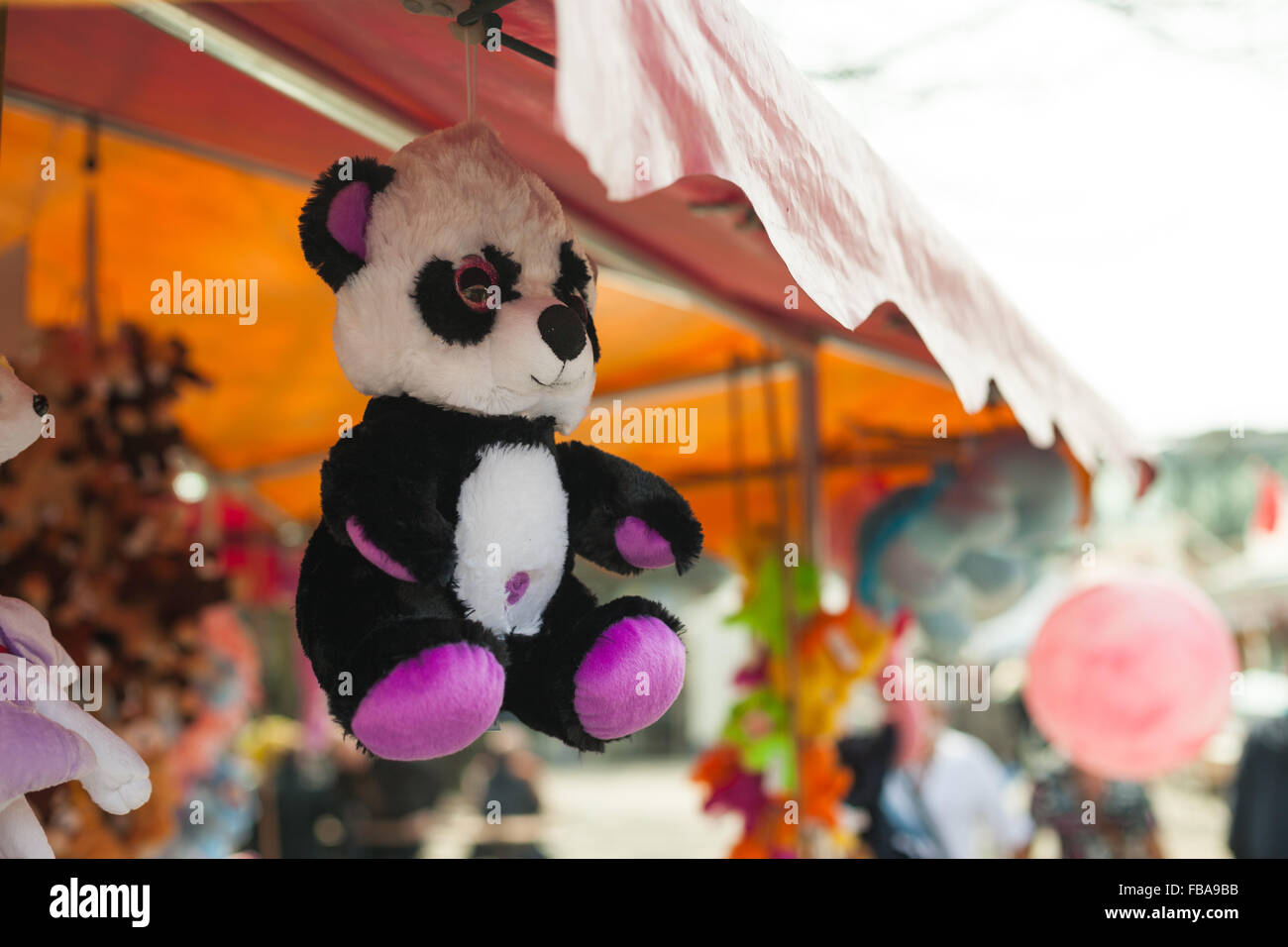 Stuffed bear hanging at a fairgrounds as a prize Stock Photo