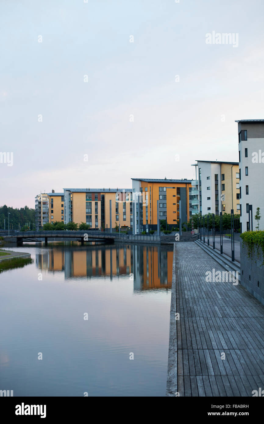 Finland, Uusimaa, Helsinki, Vuosaari, Residential buildings along canal at dusk Stock Photo