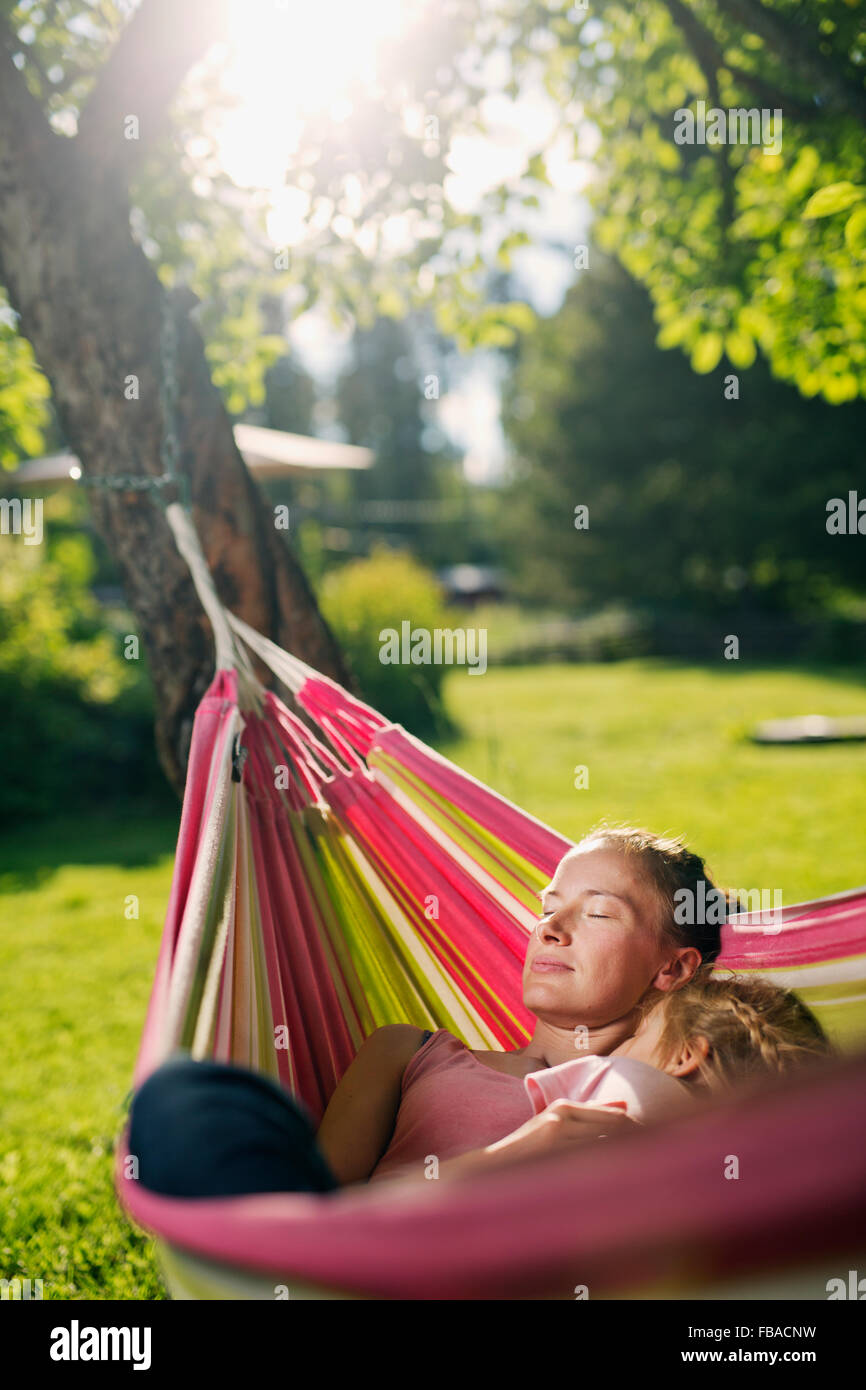 Finland, Heinola, Paijat-Hame, Woman embracing girl (4-5) in hammock Stock Photo