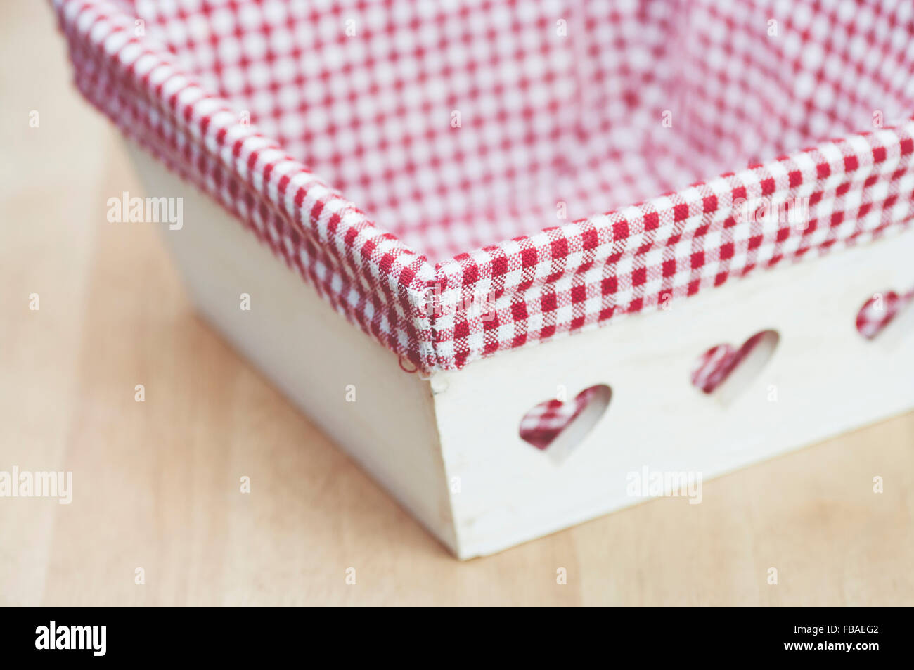 wood basket with engraved hearts and checkered fabric lining Stock