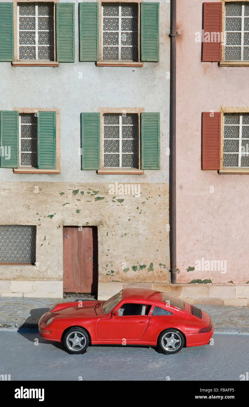 red toy car outside a fake house Stock Photo