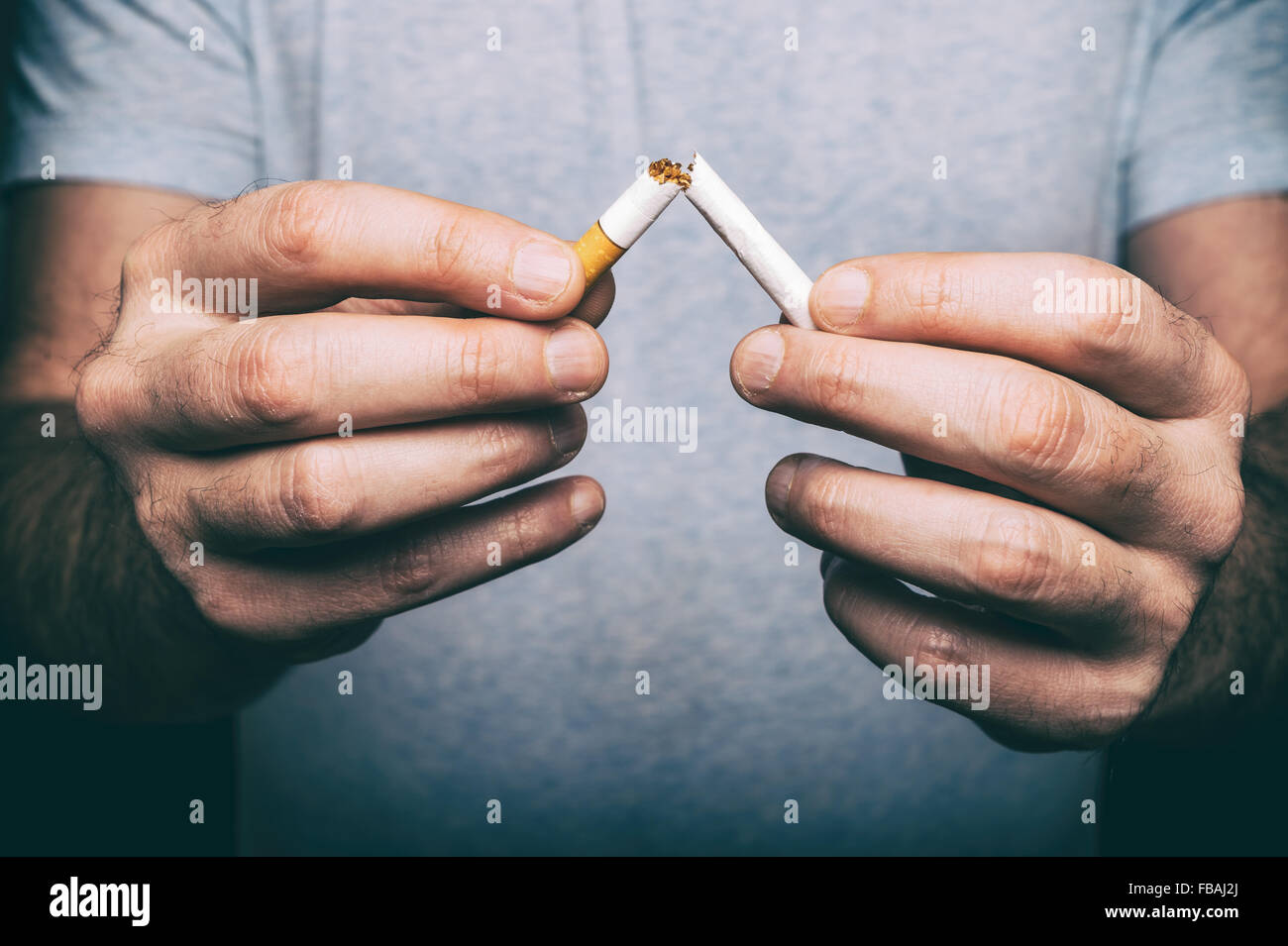 Quitting smoking - male hand crushing cigarette Stock Photo