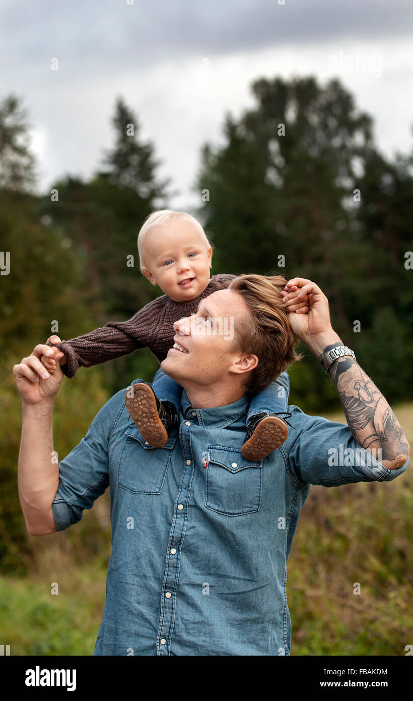 Finland, Uusimaa, Raasepori, Karjaa, Father holding son (12-17 months) piggyback Stock Photo