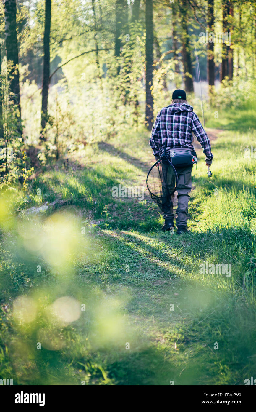 Finland, Etela-Suomen laani, Rear view of fisherman walking in forest Stock  Photo - Alamy