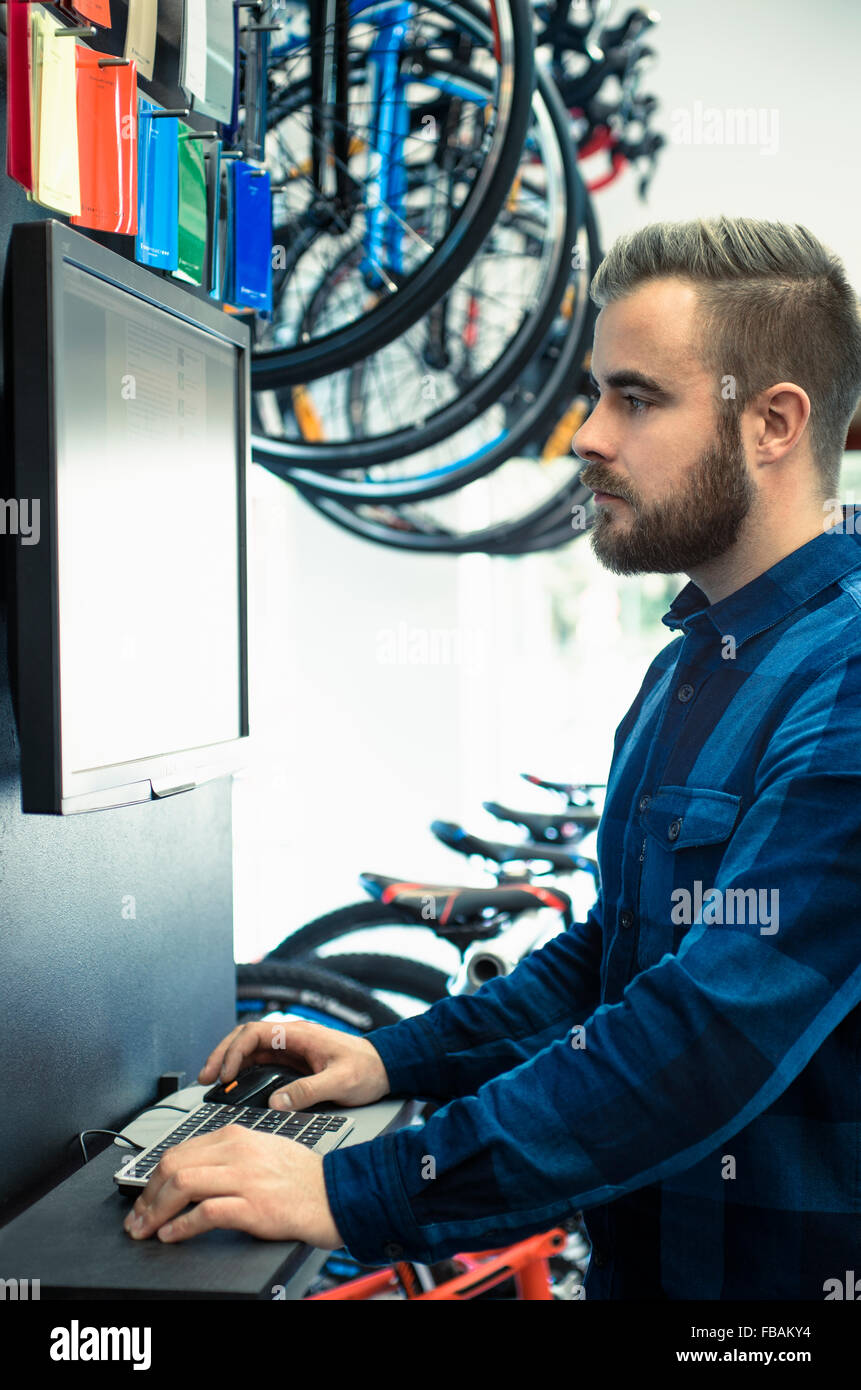 Finland, Mechanic in bike shop using computer Stock Photo Alamy