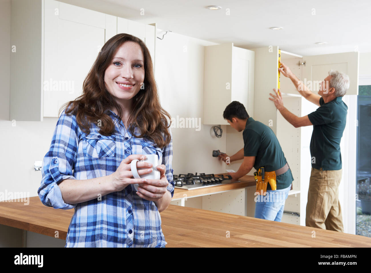 Portrait Of Woman Having New Kitchen Fitted Stock Photo