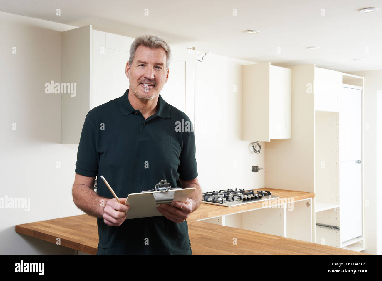 Carpenter Installing Luxury Fitted Kitchen Stock Photo