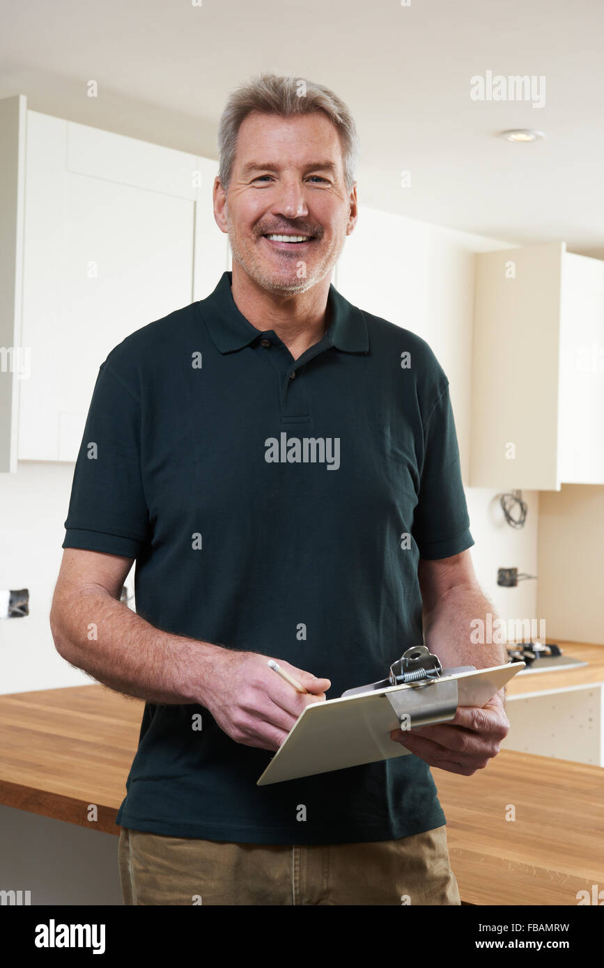 Carpenter Installing Luxury Fitted Kitchen Stock Photo