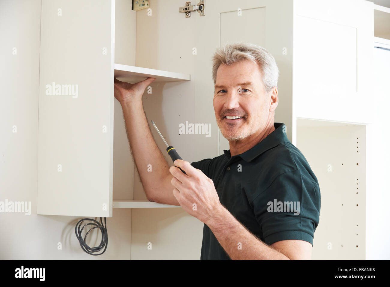 Carpenter Installing Luxury Fitted Kitchen Stock Photo