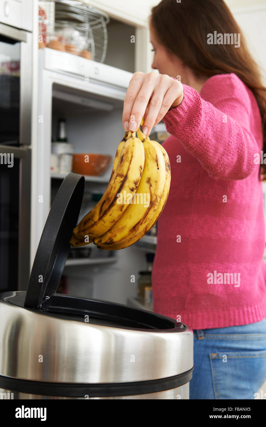 Woman Throwing Away Out Of Date Food In Refrigerator Stock Photo