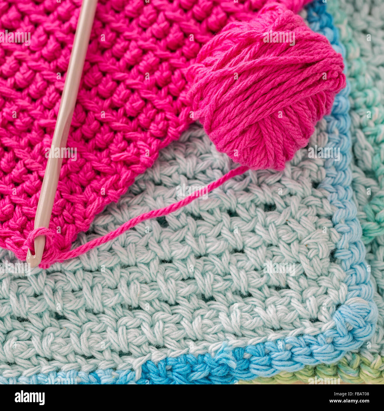 Crocheted dishcloths, with a hook and a ball of yarn. Stock Photo