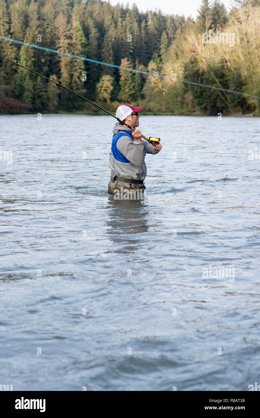 Male angler fly fishing in a river on the Olympic Peninsula in