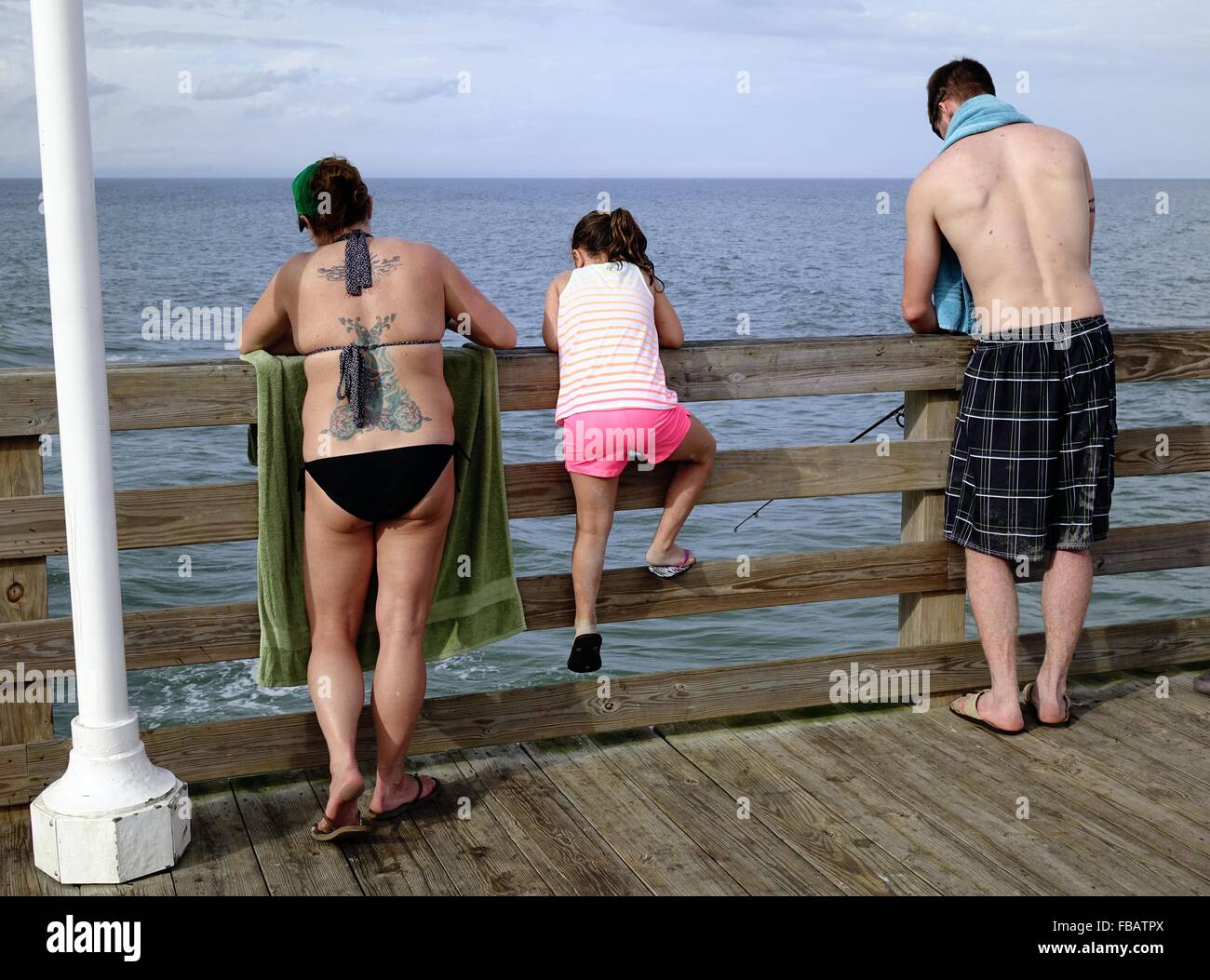 Man, woman and child fishing on the Daytona Beach pier Stock Photo