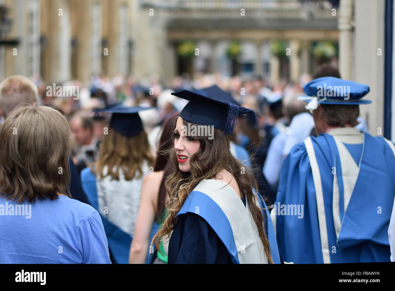 BATH, UK - JULY 16 2014 University of Bath graduands in blue gowns and mortar boards gather outside Bath Abbey Stock Photo