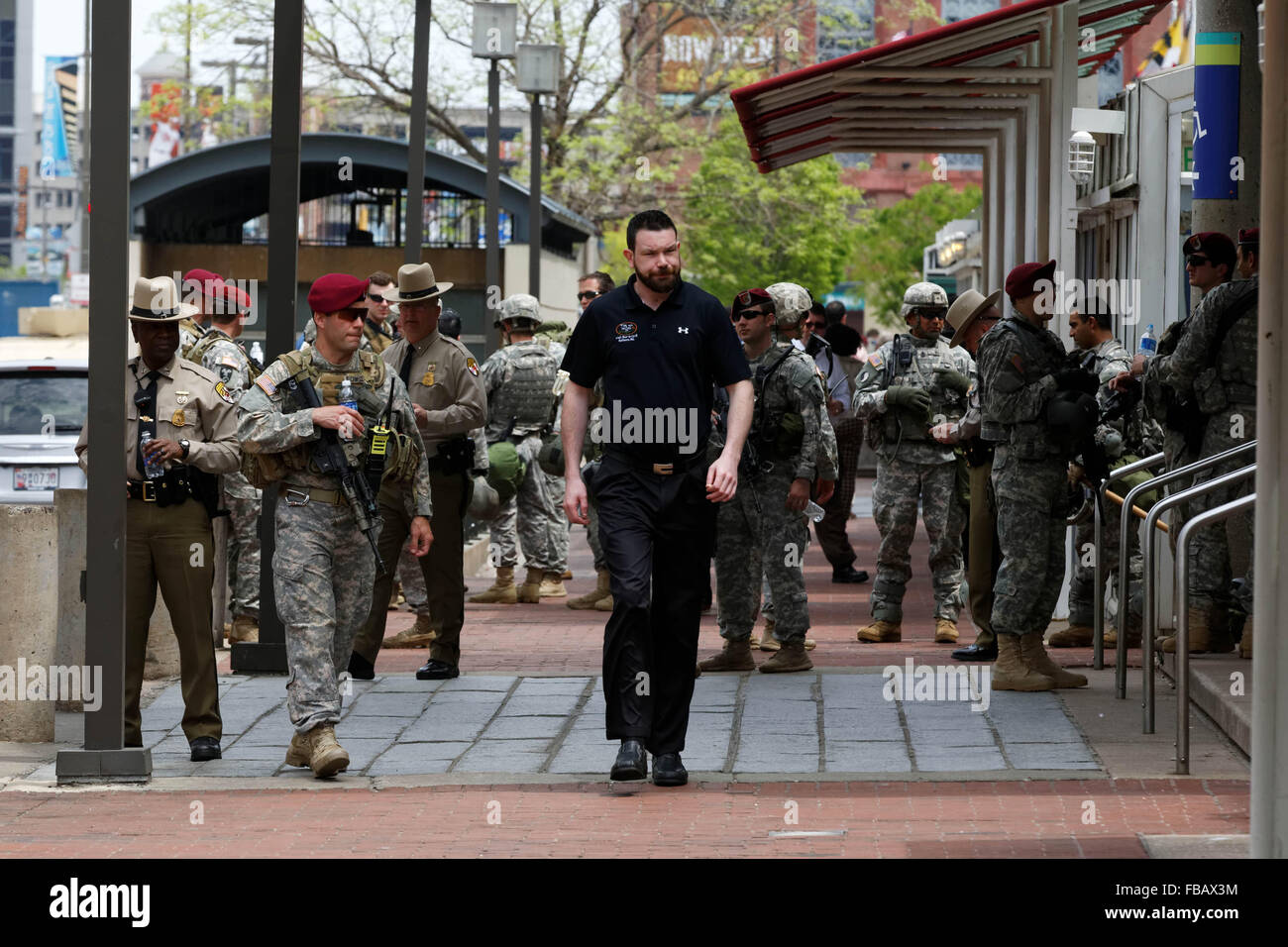 A man walks through a phalanx of National Guardsmen in the inner harbor area of Baltimore after rioting the previous night. Stock Photo