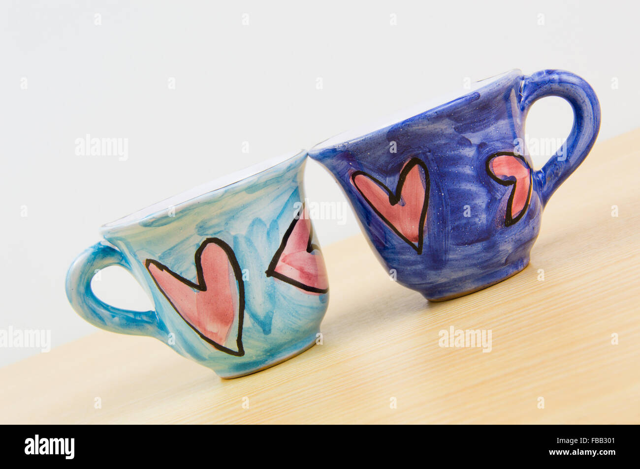 Colorful coffee cups with hand draw of love heart on wood board Stock Photo