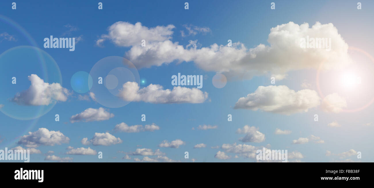 blue sky , sunlight and clouds - lens flare Stock Photo