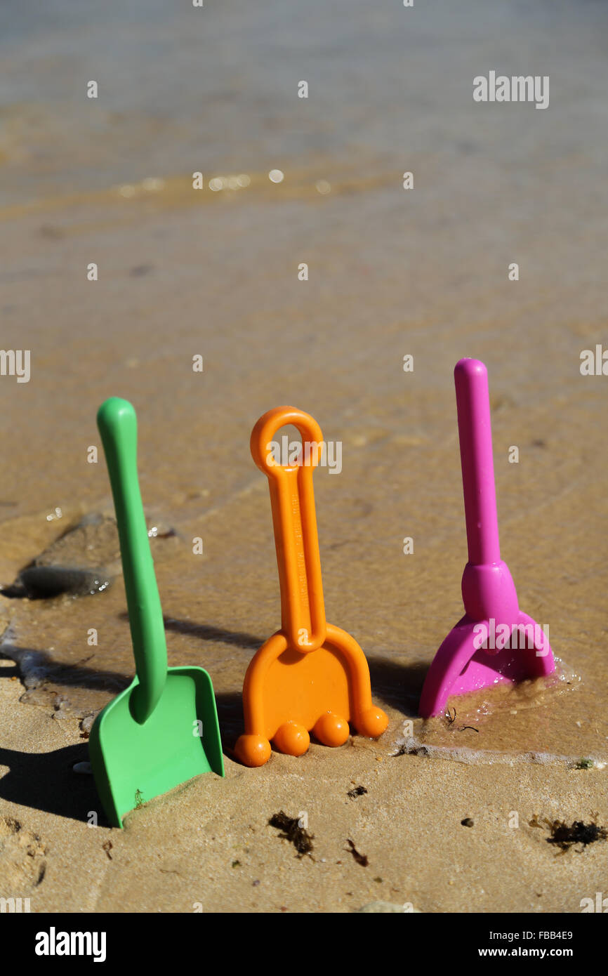 Plastic beach shovels in sand on a beach Stock Photo Alamy