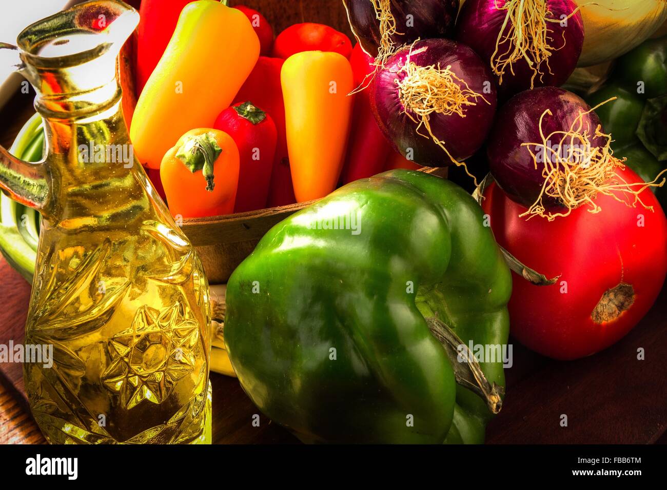 Colorful variety of fresh from the farm raw organic vegetables with a carafe of olive oil. Stock Photo