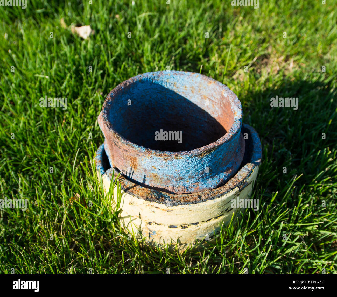 A utility or ventilation pipe of unknown purpose rusting and painted blue, water outlet of some sort perhaps. Stock Photo