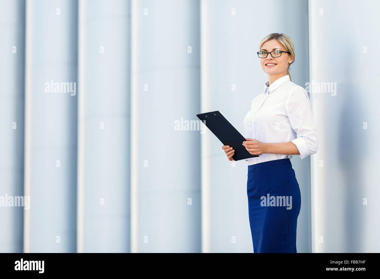 Cheerful business woman holding folder Stock Photo - Alamy