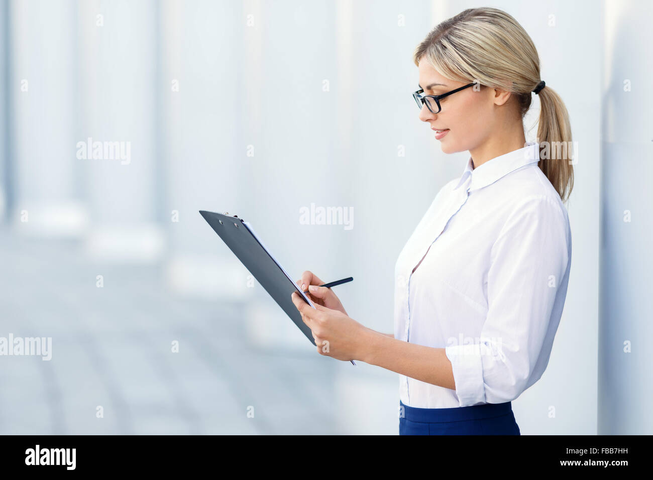 Cheerful business woman holding folder Stock Photo - Alamy