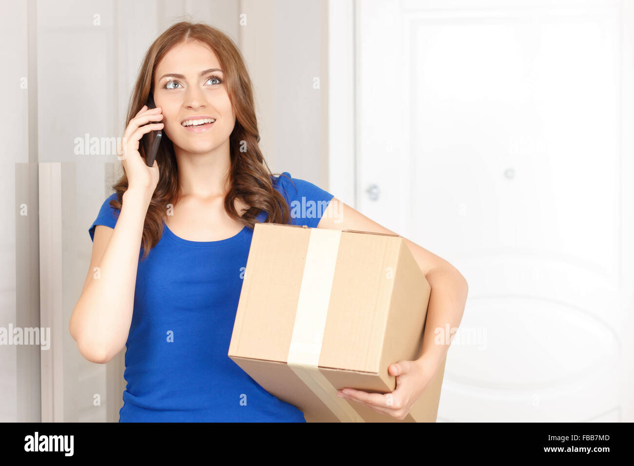 Cheerful woman holding box Stock Photo Alamy