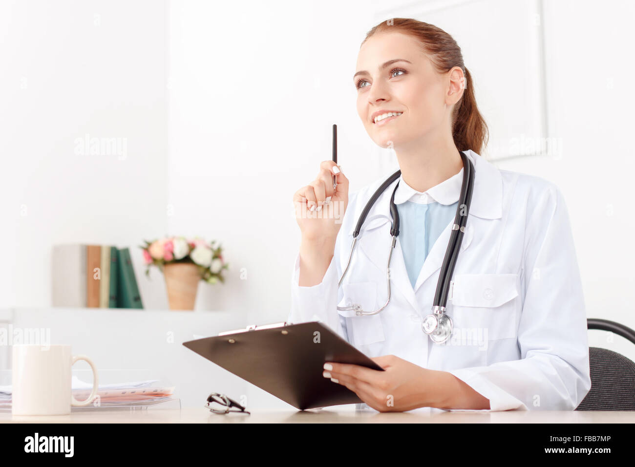 Professional doctor sitting at the table Stock Photo - Alamy