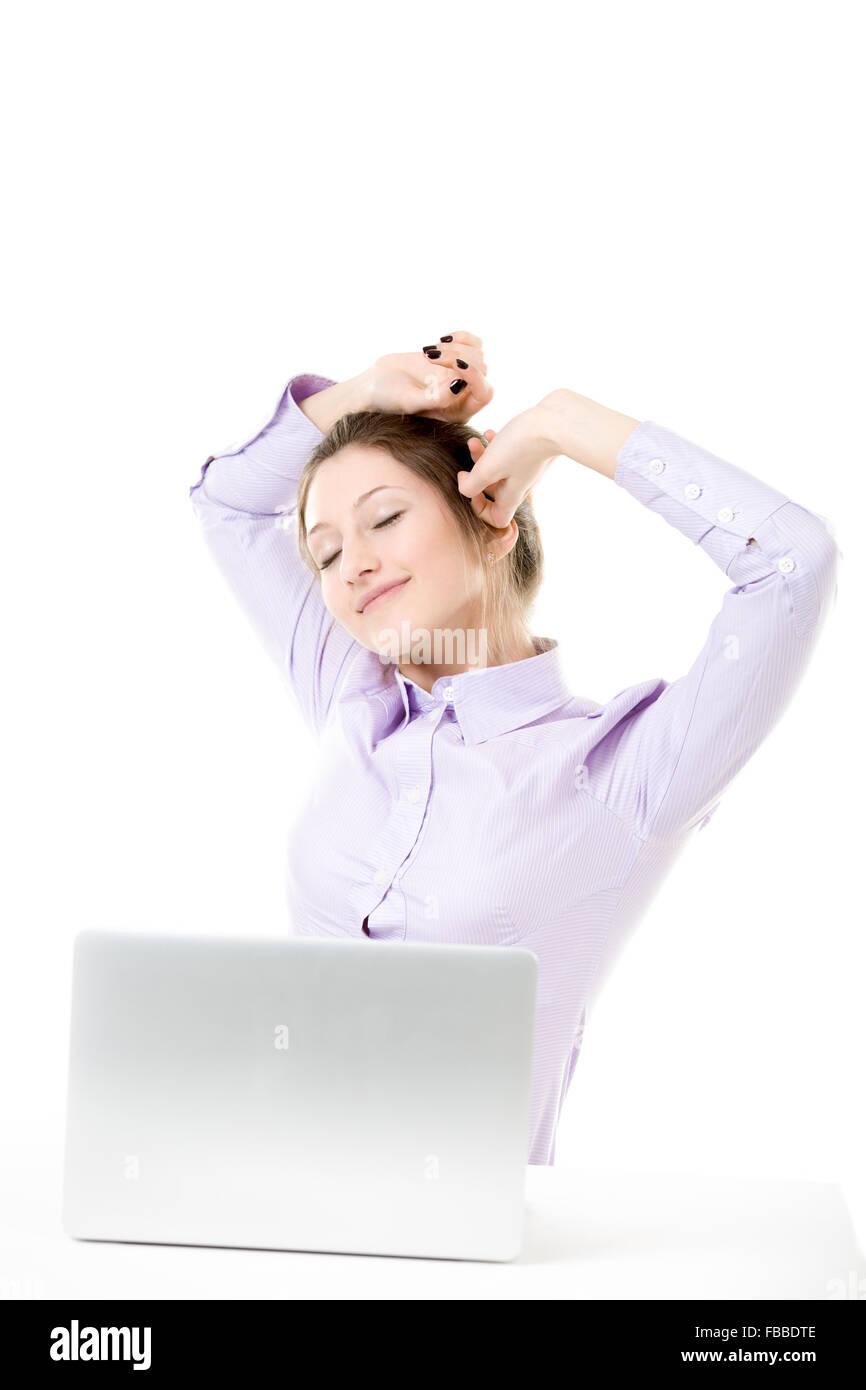 Beautiful girl tired from work stretching in front of laptop, student or business woman in formal wear happy smiling with satisf Stock Photo