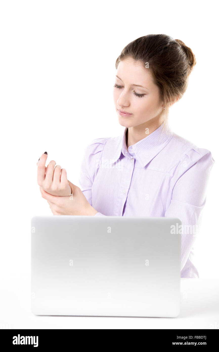 Young woman massages her sore wrist and palm after too much work on